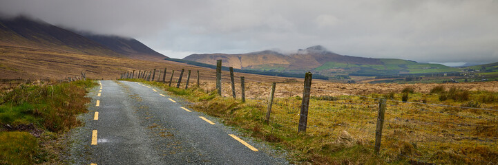 Irish road leading through the mountains, covered in clouds, near the Dingle Way