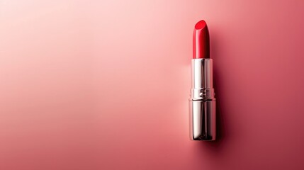 Obraz premium Add a touch of elegance: Red lipstick stick on a delicate pink background, a symbol of confidence and sophistication