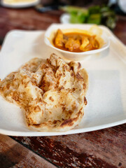 Roti Prata, popular Indian flatbread dish found in Singapore, Brunei, Indonesia and Malaysia. Asia, Asian traditional street food, made from flour bread. Close up food photo