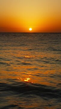 Vertical Screen: Enjoy a mesmerizing golden sunset over the ocean with waves shining under the warm sun, creating a serene moment of relaxation and tranquility. Let the beauty of nature bring peace