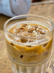 Fresh ice cappuccino in the glass on the wooden table