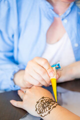Henna Artist Applying Intricate Design On Womans Wrist