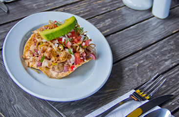 Octopus ceviche over a deep fried corn tortilla tostada.