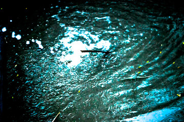 Black abstract background with glowing water splash effect