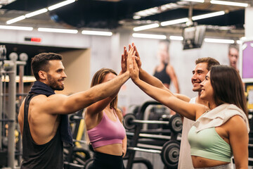 group of friends in a gym shaking hands. teammates, unity, group
