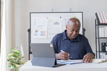 Fototapeta premium Creative african businessman senior american worker using computer device in office,chat online, thinking business solution planning difficult decision pondering strategy come up with idea.
