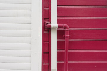 Obraz premium red wall with pipe, displaying modern urban design with vibrant colors