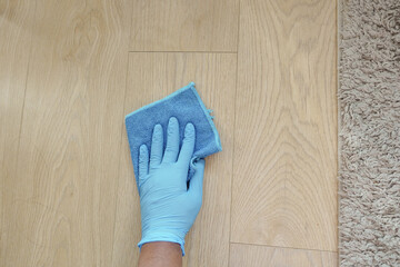 A man's hand washing the floor with a cloth 