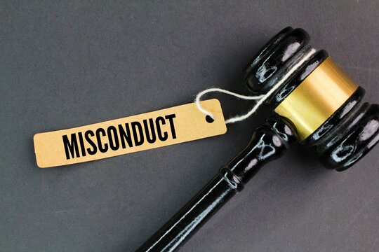 the judge's gavel and a paper tag with the word misconduct. employee or student fault concept