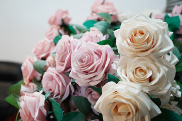 Bouquet of white and pink roses with green leaves close up