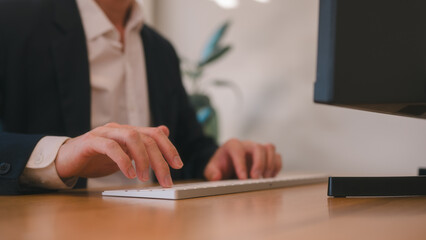 Business man hands typing on wireless computer keyboard searching information, surfing the internet...