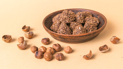 Chocolate Hazelnut Cookies in Wooden Bowl with Hazelnuts on Beige Background
