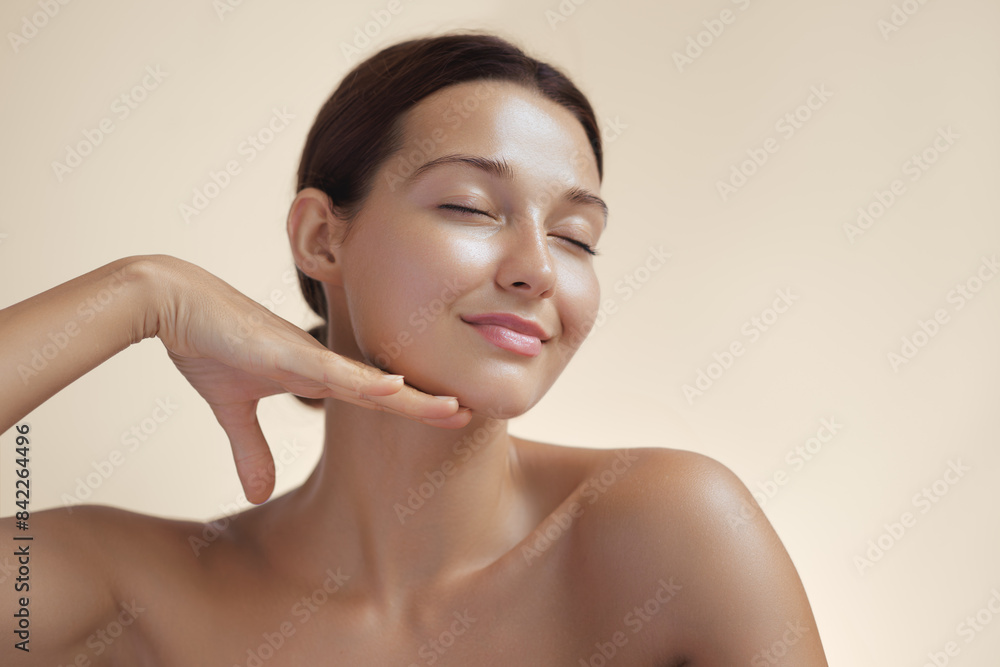 Wall mural photo of natural beauty woman with radiant skin touching by hand