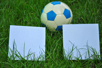 two white square sheets on green grass and a soccer ball. creative scoreboard. Scoreboard concept...