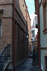 Fototapeta premium narrow street with lanterns between houses in the center of old Tbilisi