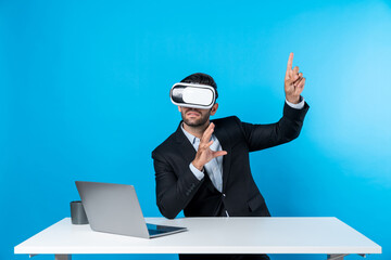 Skilled business man looking at data analysis while sitting at table with laptop and wearing VR glasses. Project manager working by using virtual reality system or connecting at metaverse. Deviation.