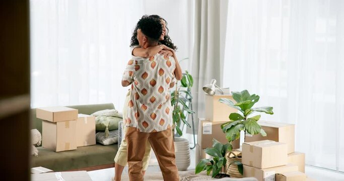 Moving, boxes and couple hugging in living room for celebration, happiness and achievement together. Homeowners, excited and young man and woman embracing for pride and bonding in new apartment.