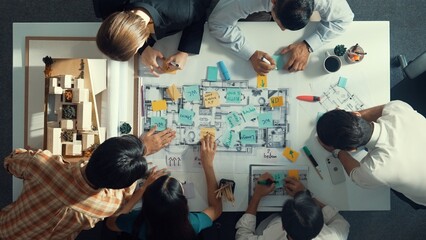 Top aerial view of project manager or civil engineer writing at blueprint and planning building...
