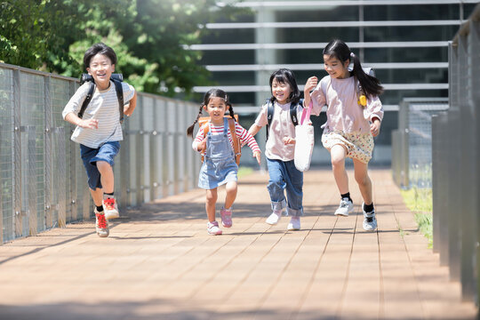 ランドセルを背負って走る、ダッシュする小学生の全身 未来や希望、元気なイメージ