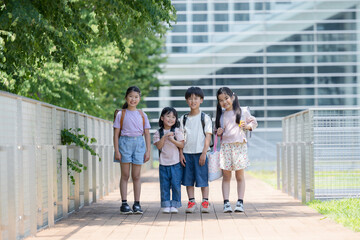 登校する笑顔の小学生のカメラ目線の全身　複数　の広角