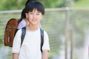 Camera view of elementary school boy with school bag on his back, close-up with copy space on the right