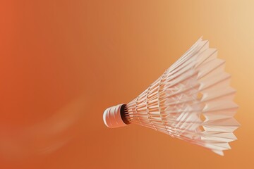 A white shuttlecock is flying through the air