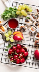 Marshmallow skewers and and strawberry, cherry, grame on light wooden background. Summer party food