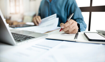 Asian businessman work and meeting online with laptop making notes, review document and business contract