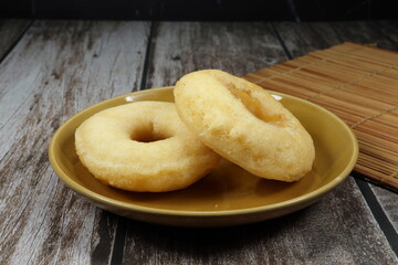 Classic baked donut dough serving on the plate. Famous pile of sweet dessert in Bakery shop.