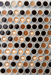A top-view of a simple table with forty cups of coffee, arranged in a neat pattern, against a stark white background