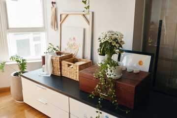 Dresser with pottery flowers, framed pictures and boxes on top