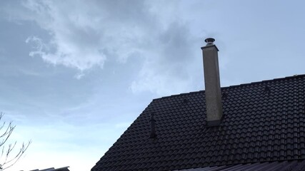 House roof and chimney under a cloudy sky on a rainy day, light drizzle falling - Powered by Adobe