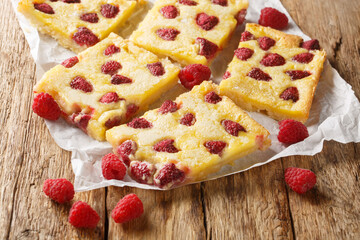 Sweet custard pie tart with fresh berry raspberries closeup on the paper on the wooden table....