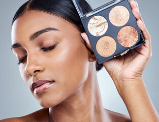 Woman, makeup palette and beauty with eyes closed in studio for wellness, face and product for...
