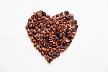 Roasted coffee beans forming a heart  on a white background in prefect details.