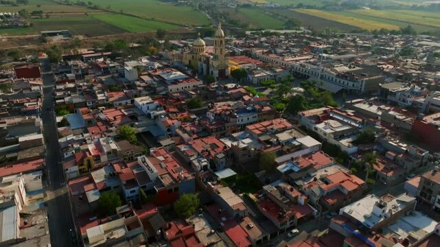 Dolly in tilt up flight over residential area reveals Santuario Diosesano church in Tamazula city center. Jalisco, Mexico