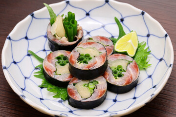 A Japanese sushi restaurant roll dish of pickled sardines and ginger wrapped in nori seaweed.