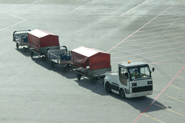 Airport vehicles idea concept. Truck with trailers for transportation luggages in airport. 