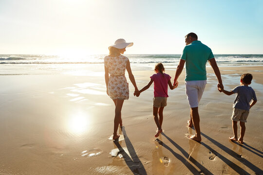 Love, holding hands and family walking at a beach for sunset, travel and bonding in nature together. Support, back and children with parents at sea for adventure, journey or trip in Florida with care - Powered by Adobe