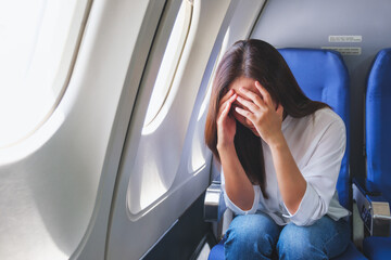 Portrait image of a woman get airsick and headache while traveling on airplane