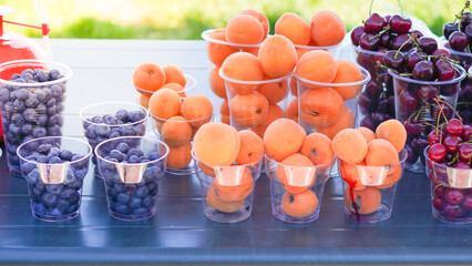 Juicy fruits and berries in plastic cups, perfect for a hot day refreshment