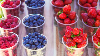 Juicy fruits and berries in plastic cups, perfect for a hot day refreshment