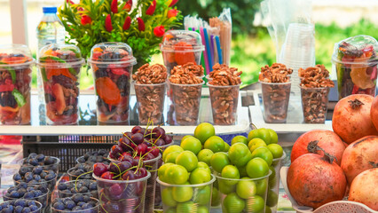 Juicy fruits and berries in plastic cups, perfect for a hot day refreshment