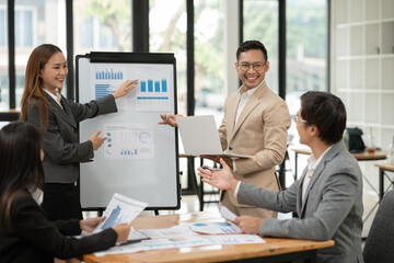 Asian business group discussing graph work at the office..