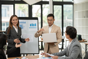 Asian business group discussing graph work at the office