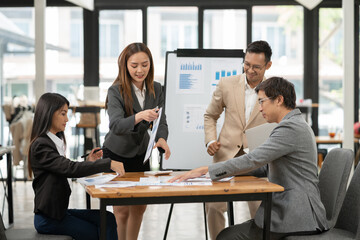 Asian business group discussing graph work at the office