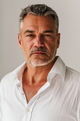 Obraz premium A person in a white shirt poses directly facing the camera, making eye contact with the viewer