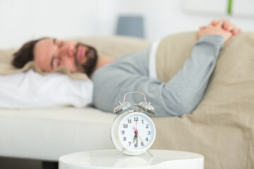 man fast asleep alarmclock in foreground
