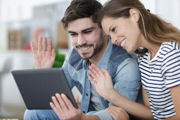 couple looking at tablet on sofa at home