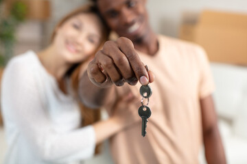 young couple holding up new house key